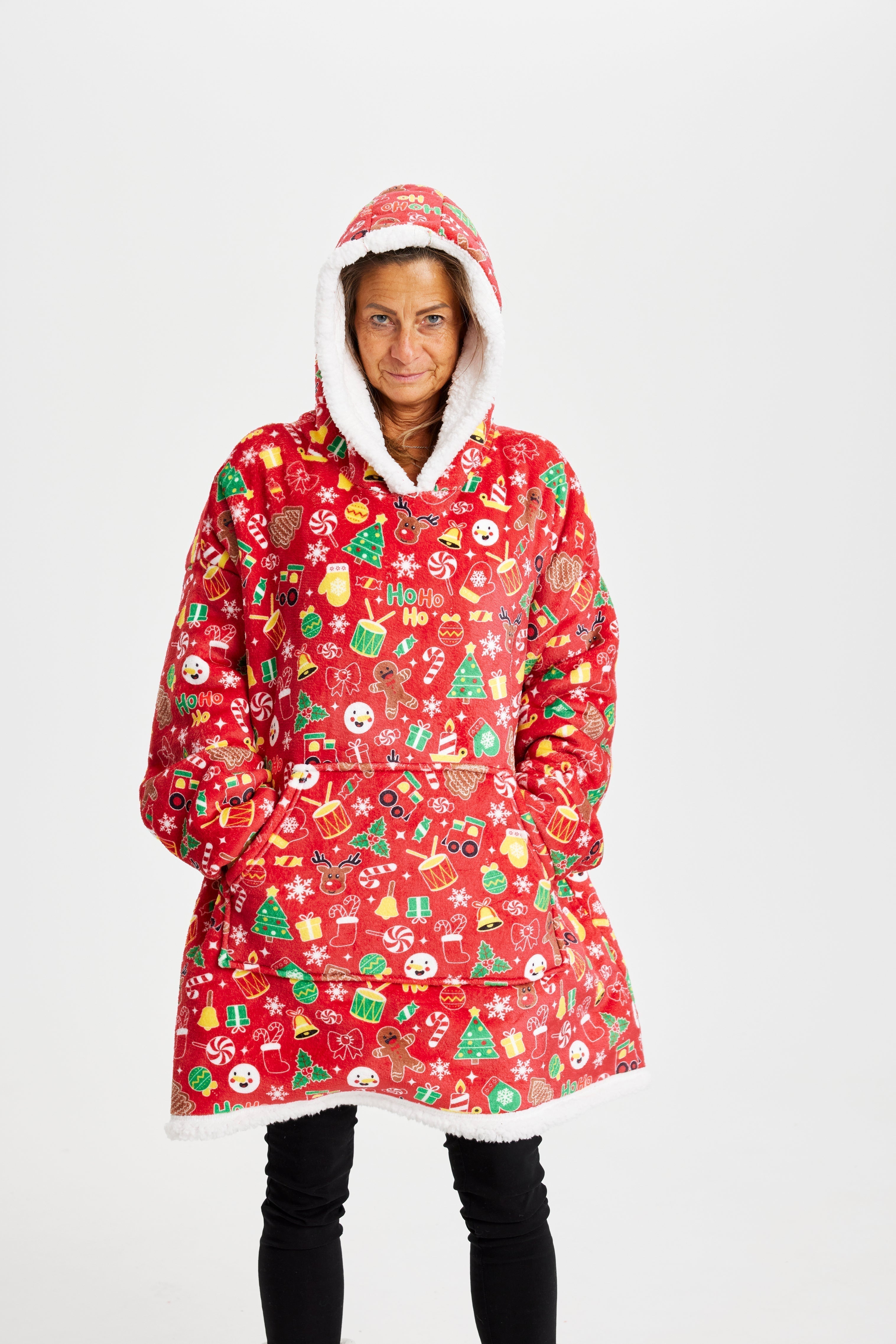 Une femme porte un sweat à capuche rouge avec un motif de Noël.